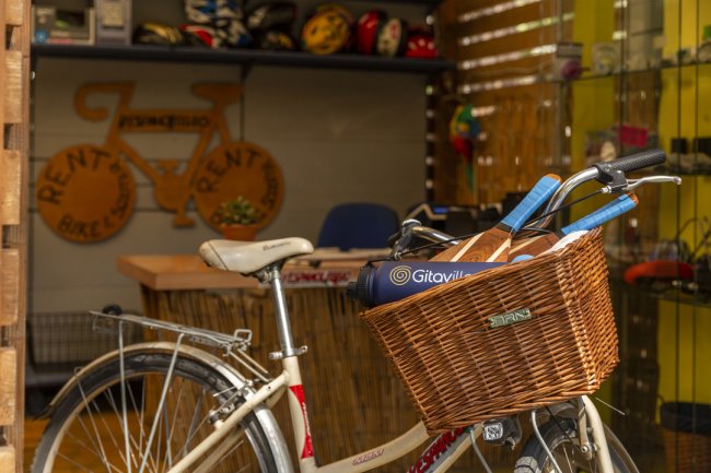 Bicicletta con cestino, davanti a un negozio di noleggio bici.