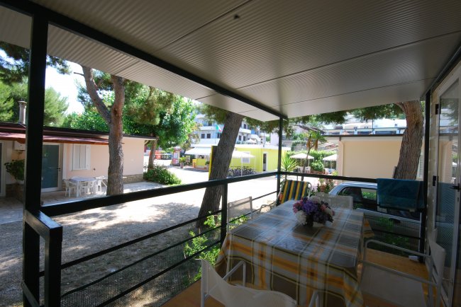 Un portico coperto con tavolo e sedie.