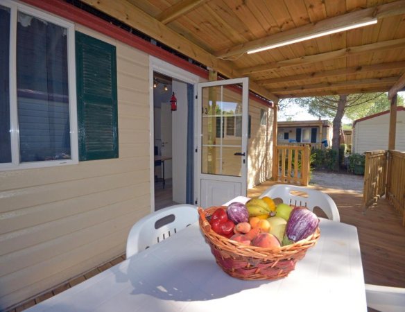Veranda con tavolo e cesto di frutta.