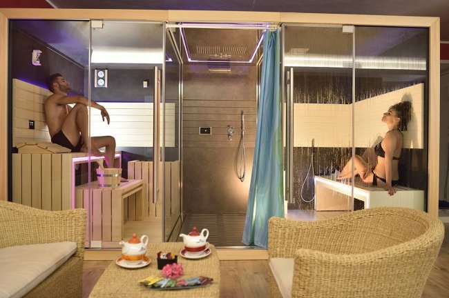 Spa con sauna e doccia, due persone rilassate.