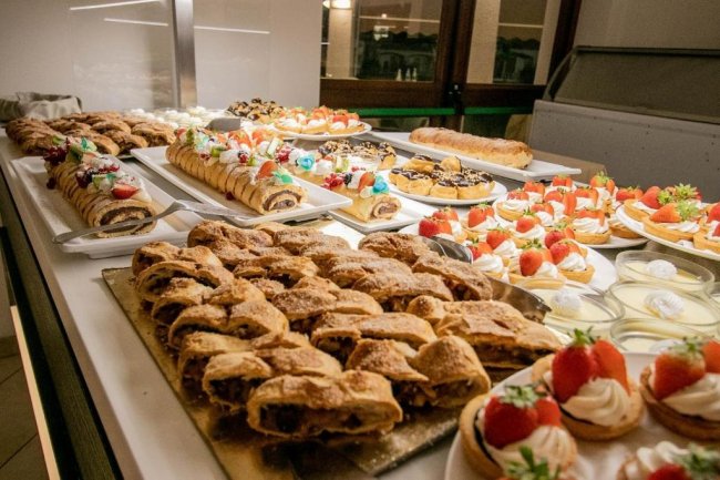 Buffet di dolci vari con fragole e panna.
