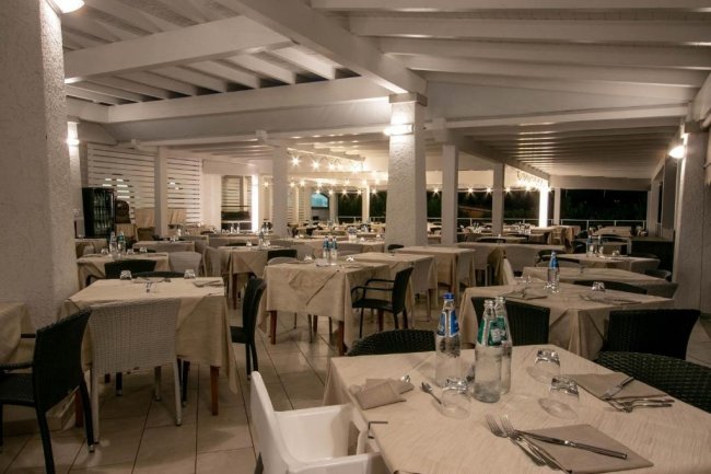 Sala da pranzo all'aperto con tavoli apparecchiati.