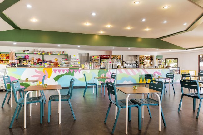 Sala ristorante spaziosa con tavoli e sedie blu.