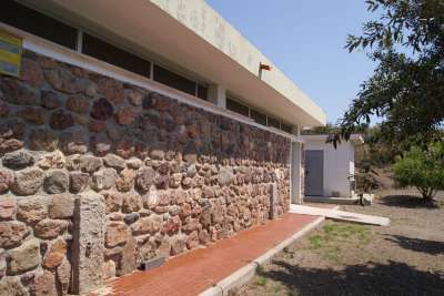 Facciata di un edificio in pietra con un sentiero di mattoni rossi.