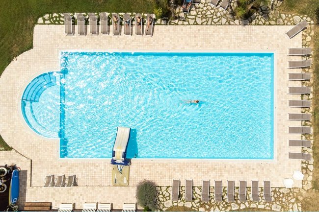 Vista aerea di una piscina con nuotatore.