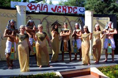Sei persone in costumi egiziani dorati con scenografia a tema Baia Verde.