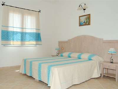 Camera da letto con letto matrimoniale, lampade coordinate e quadro alle pareti.