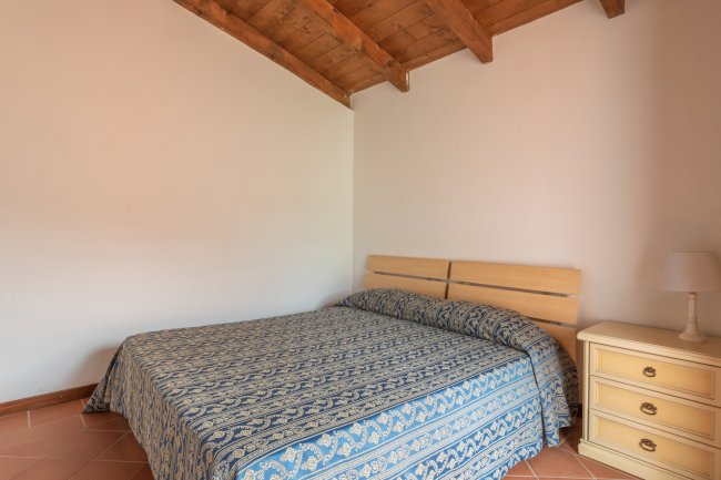 Letto matrimoniale con copriletto blu.