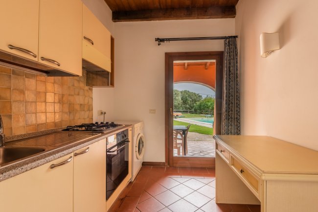 Cucina con porta finestra su giardino.