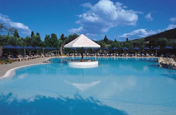 Piscina all'aperto con una struttura bianca centrale e sky blu.