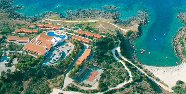 Vista aerea di una struttura turistica con piscine, edifici e costa.