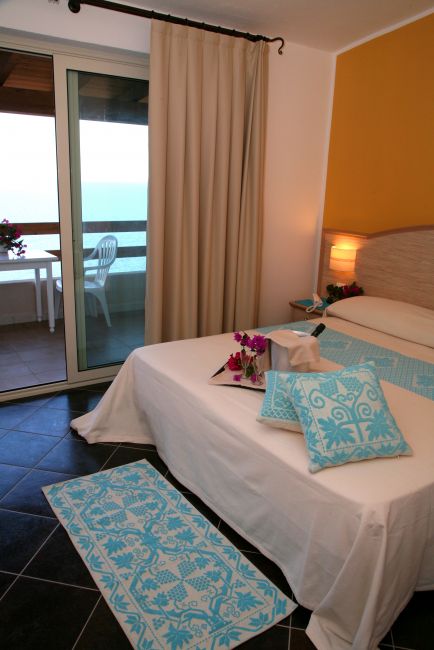 Stanza con letto e terrazza vista mare.