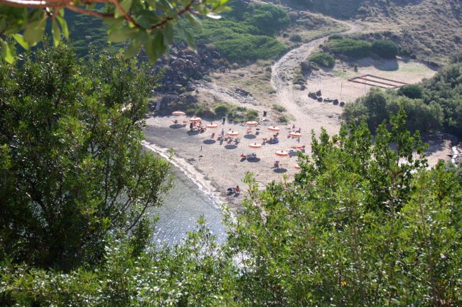 Vista aerea di una spiaggia con ombrelloni arancioni.