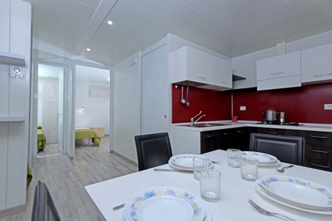 Cucina moderna con tavolo apparecchiato e sedie nere.
