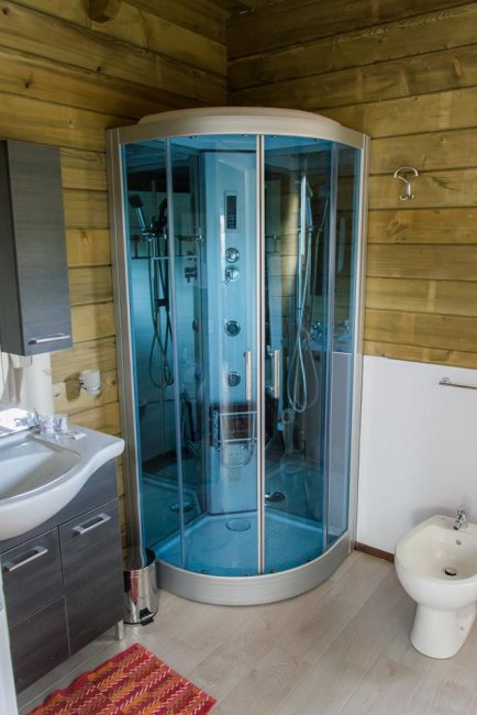 Bagno con cabina doccia moderna, lavabo e bidet.