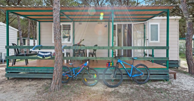 Casetta con veranda e due biciclette parcheggiate.
