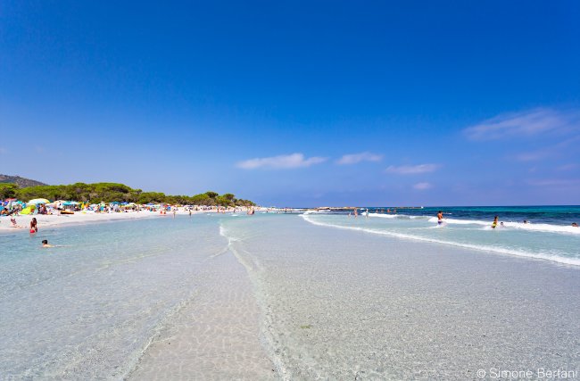 Spiaggia con mare trasparente e cielo blu.